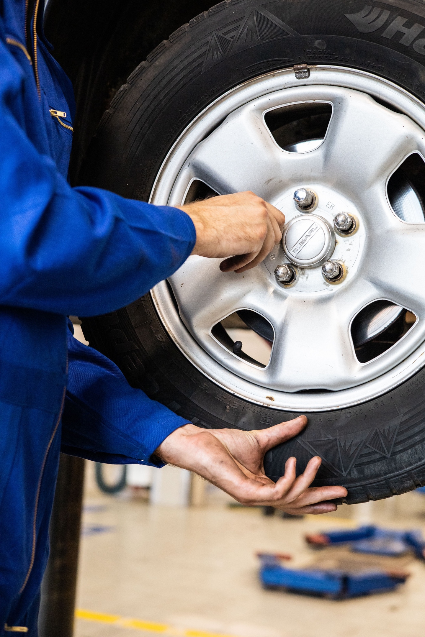 Mechanic's hands removing lug nuts from a wheel