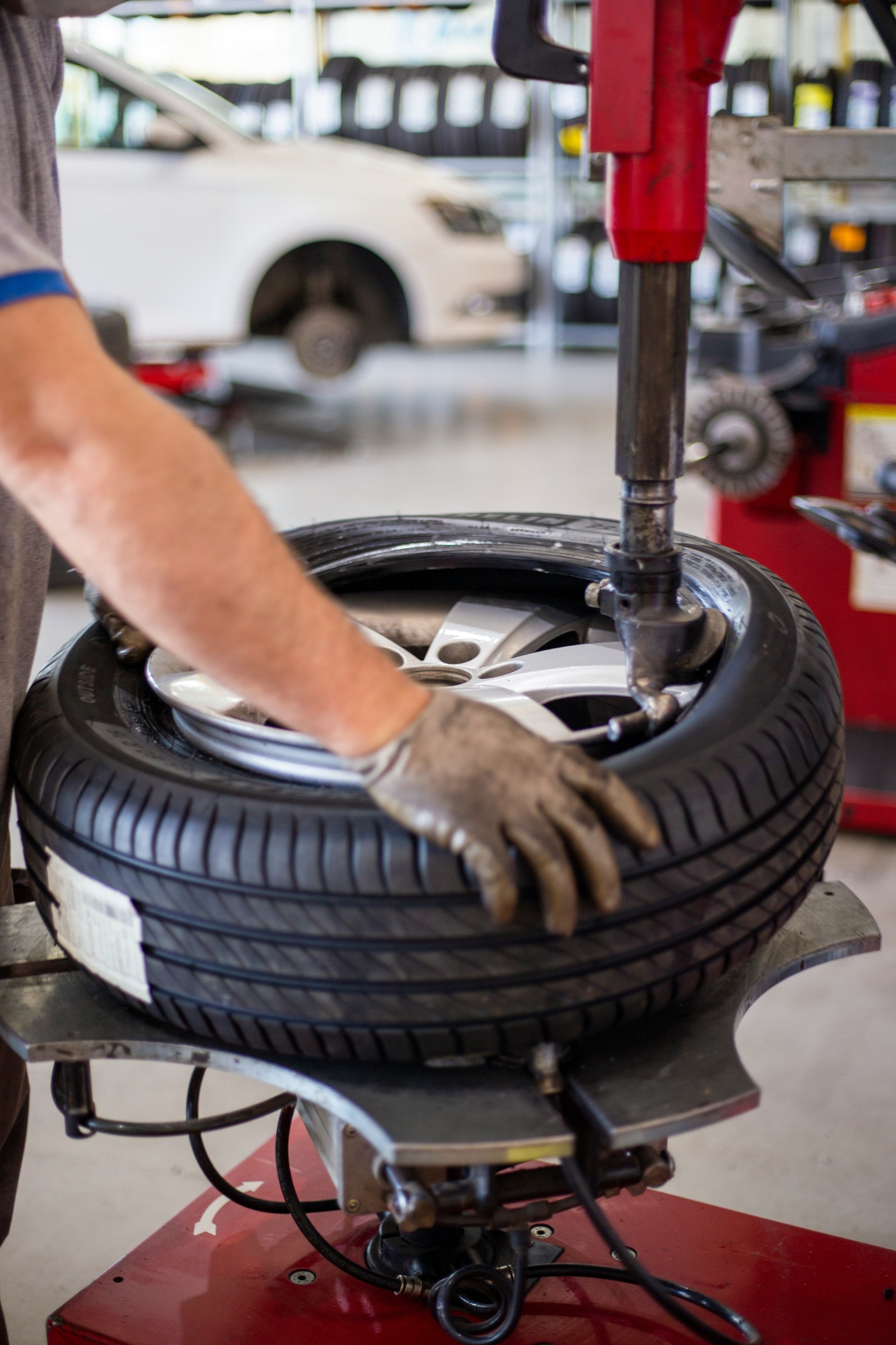 Technician mounting a tire on a wheel balancer